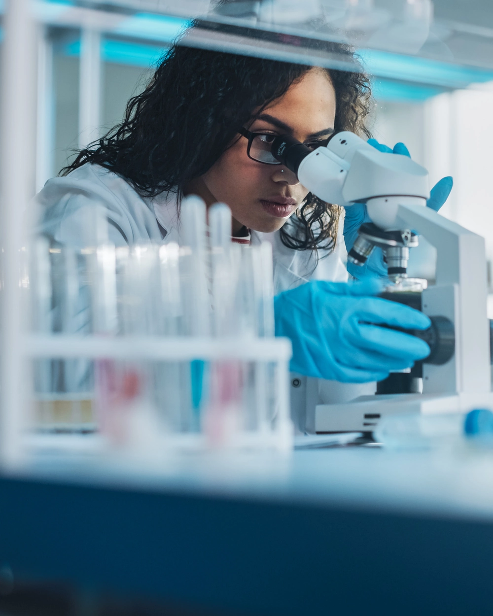 Researcher examining a sample through a microscope