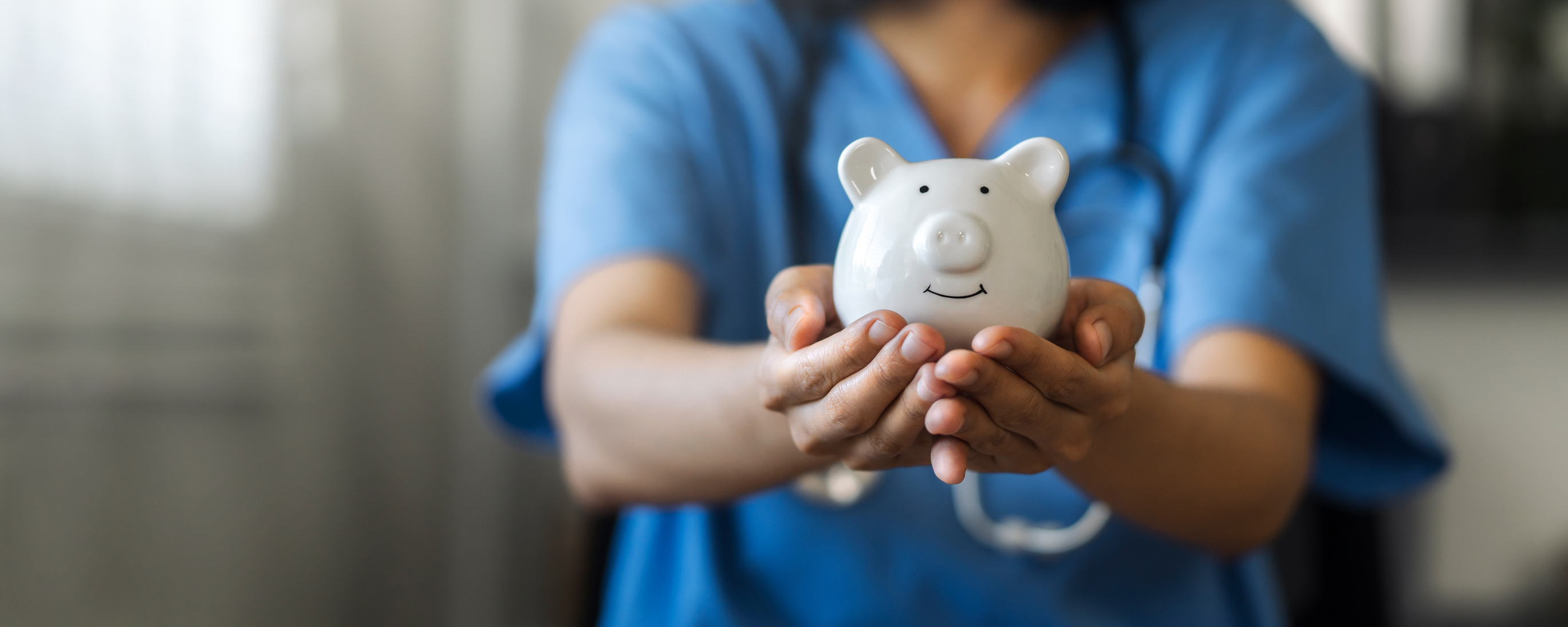Healthcare professional holding a piggy bank, with a stethoscope