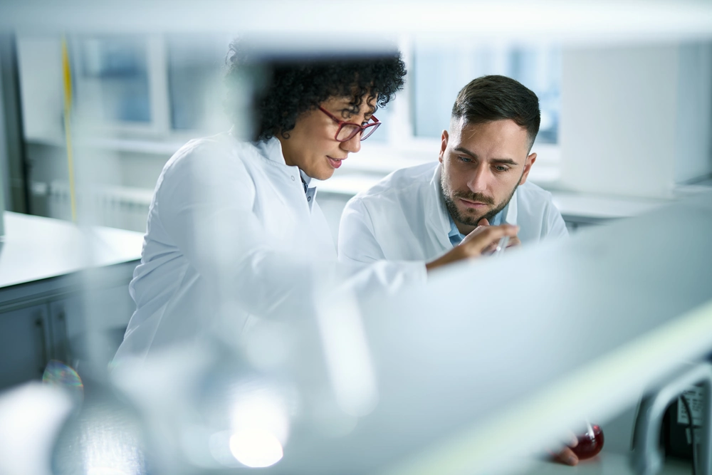 Two scientists reviewing work together in a laboratory